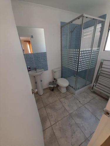 a bathroom with a toilet and a glass shower at Cabañas Herradura Oriente in Coquimbo