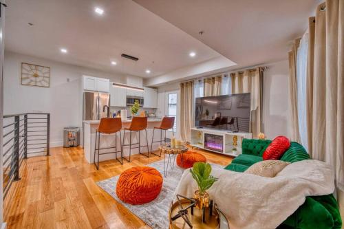 a living room with a green couch and a kitchen at Modern & Colorful ~ 5* Location in Washington, D.C.