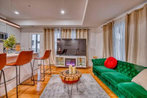 a living room with a green couch and a television at Modern & Colorful ~ 5* Location in Washington, D.C.