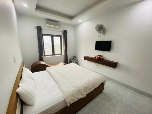 Un pat sau paturi într-o cameră la Khách sạn Phú Hưng