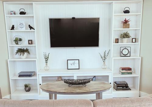 a living room with a tv and a coffee table at Cozy Villa 3 mins to Mohegan- Fully Stocked with King Bed & Fireplace- Jacuzzi, Saltwater Pools, Sauna in Norwich