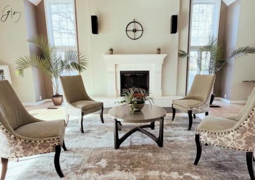 a living room with chairs and a fireplace at Cozy Villa 3 mins to Mohegan- Fully Stocked with King Bed & Fireplace- Jacuzzi, Saltwater Pools, Sauna in Norwich
