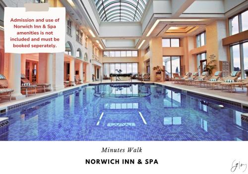 a large indoor swimming pool in a building at Cozy Villa 3 mins to Mohegan- Fully Stocked with King Bed & Fireplace- Jacuzzi, Saltwater Pools, Sauna in Norwich