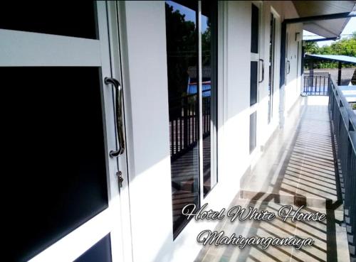 a sliding glass door on a house with a porch at Hotel white house mahiyanganaya in Mahiyangana