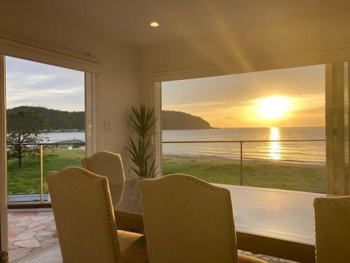 a dining room with a table and a view of the ocean at H&H Calme in Minamiboso