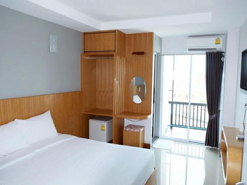 a bedroom with a bed and a large window at @Me2 Hotel in Phitsanulok