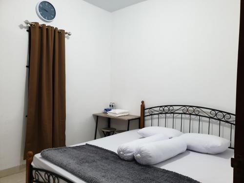 una camera da letto con un letto con cuscini bianchi di HAPDESKO HOMESTAY a Batam Center
