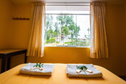 um quarto com duas toalhas numa cama com uma janela em La Posada de Lucero em Chivay