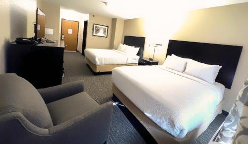 a hotel room with two beds and a chair at Country Trails Inn &Suites in Lanesboro