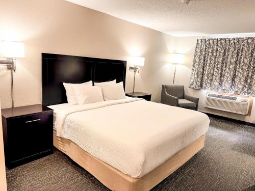 Lanesboro的住宿－Country Trails Inn &Suites，酒店客房带一张大床和一把椅子