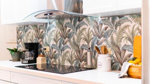 a kitchen with a tropical wallpaper on the wall at Casa Sol in Trujillo