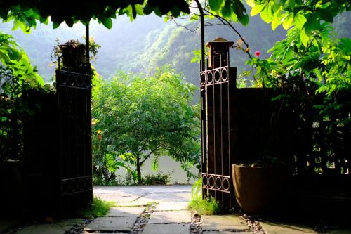 an open gate with a view of a mountain at Blue Lagoon Cat Ba in Cat Ba