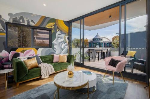 a living room with a green couch and a table at Sky Maiden on King with Private Terrace in Newcastle