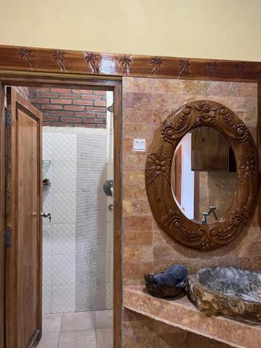 a bathroom with a mirror and a sink at Indah Riverside Villa Yogyakarta in Piyungan