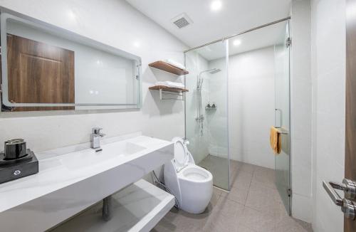 Baño blanco con lavabo y aseo en Hồng Ngọc Hotel en Ðông Thôn