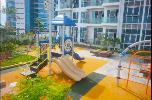 a playground in front of a large building at Fully Furnished Condo in Mactan Newtown with WIFI -Infinity Pool in Lapu Lapu City