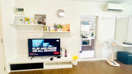 ホアヒンにあるBaan Kun Koey Condo Huahin B103,Pool View,Heart of Huahin,Near Blue Ports,300m from Beachのリビングルーム(白いテーブル、薄型テレビ付)