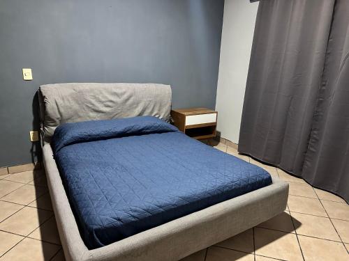 a bed with a blue blanket on it in a room at Casa Valentina in Sayula