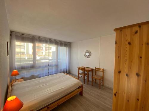 une chambre avec un lit, une table et une fenêtre dans l'établissement Appartement avec Piscine, Terrasse et Parking à Capbreton, Proche du Port - FR-1-413-198, à Capbreton