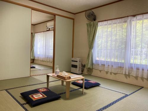 a living room with a table and a window at Pension Kaoru in Kiso