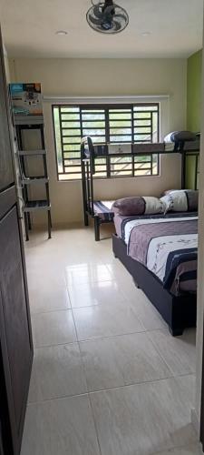 a bedroom with two beds and a tiled floor at Quinta el Progreso in Carmen de Apicalá