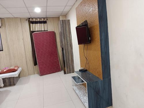 Zimmer mit einem TV an der Wand in der Unterkunft Hotel Standard in Ujjain