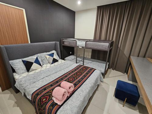 1 dormitorio con 2 literas y toallas rosas en Lovely Kozi Square comfort Studio Home 3D, en Kuching