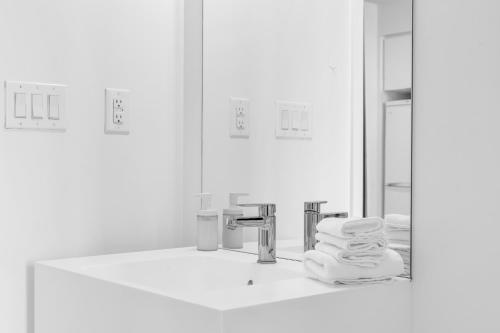 La salle de bains est pourvue d'un miroir et d'un lavabo avec des serviettes. dans l'établissement Downtown Condo - Free Parking/Self Check-in, à Toronto