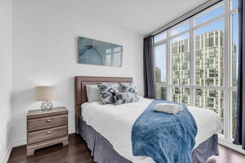 a bedroom with a bed and a large window at Downtown Condo - Free Parking/Self Check-in in Toronto