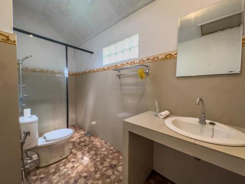 a bathroom with a toilet and a sink and a shower at Mulia Garden Bungalows in Tabanan
