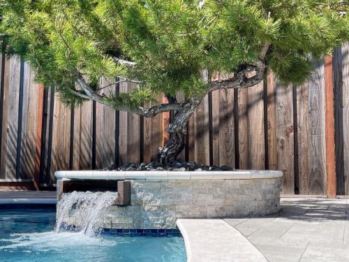 a pine tree in a fountain next to a fence at Redwood Oasis, Grove and Nook in Felton