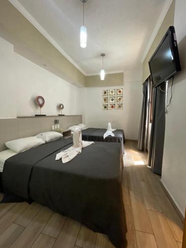 a bedroom with two beds and a flat screen tv at Hotel Palace Puebla in Puebla