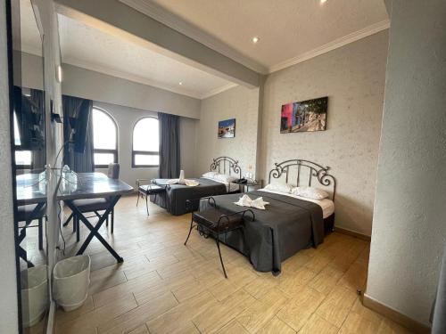 a room with two beds and a desk in it at Hotel Palace Puebla in Puebla