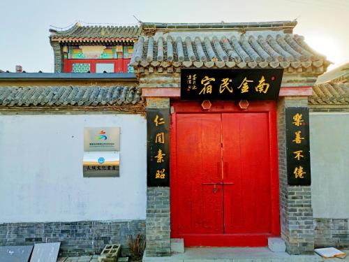 a red door of a building with writing on it at 南金民宿 in Qinhuangdao