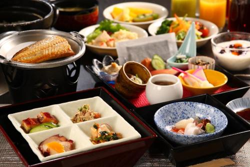 a table topped with trays of different types of food at Shogetsu Grand Hotel in Jozankei
