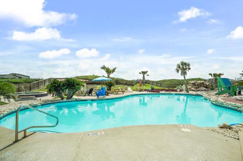 a large blue swimming pool with palm trees at K and J Port Aransas in Padre Island