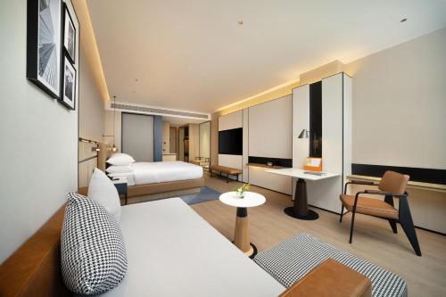 um quarto de hotel com um sofá branco e uma cama em Four Points by Sheraton Chengdu, High-Tech Zone Exhibition Center em Chengdu