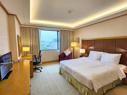 a hotel room with a large bed and a window at Hilton Garden Inn Hanoi in Hanoi