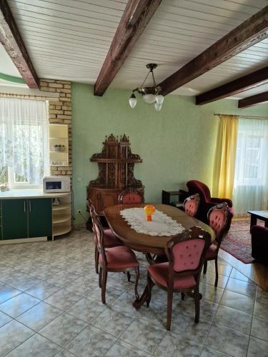 a living room with a wooden table and chairs at Kranto Vila in Kaunas