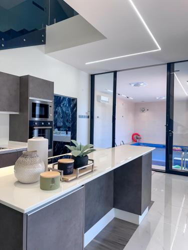 a kitchen with a large white counter with plants on it at calm chalet گالم شالية in Ţaymissah