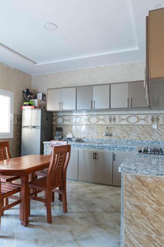 a kitchen with a table and chairs and a refrigerator at Appartement familial in Dakhla