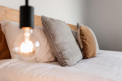 a bed with pillows and a lamp on it at Change Overnight in Launceston