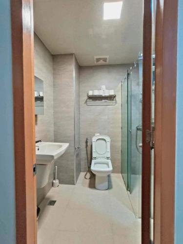 a bathroom with a toilet and a shower and a sink at Antara Residence Studio Condo in Talisay