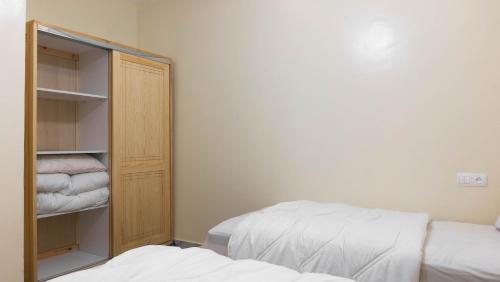a bedroom with a bed and a closet with towels at Appartement familial in Dakhla