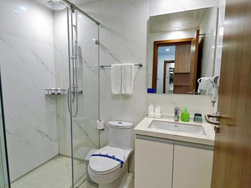 La salle de bains est pourvue d'une douche, de toilettes et d'un lavabo. dans l'établissement Beijing CSN Pearl Hotel, à Pékin
