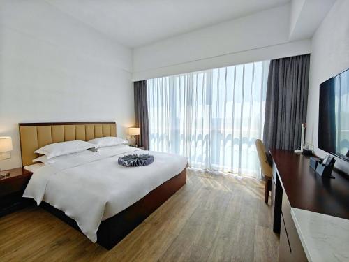 sypialnia z dużym łóżkiem i dużym oknem w obiekcie Beijing CSN Pearl Hotel w Pekinie