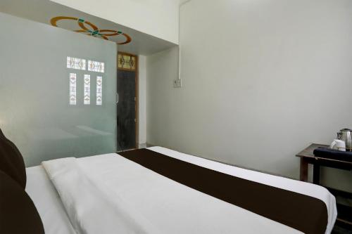 a bedroom with a bed with a black and white blanket at OYO Hotel Highway Destiny in Morādābād
