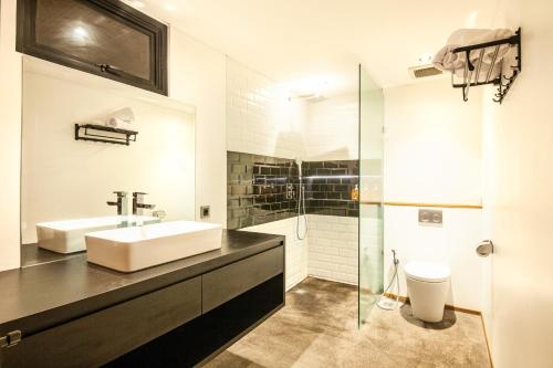 a bathroom with a sink and a glass shower at Expansive Loft 200m From Canggu Beach Haven in Canggu