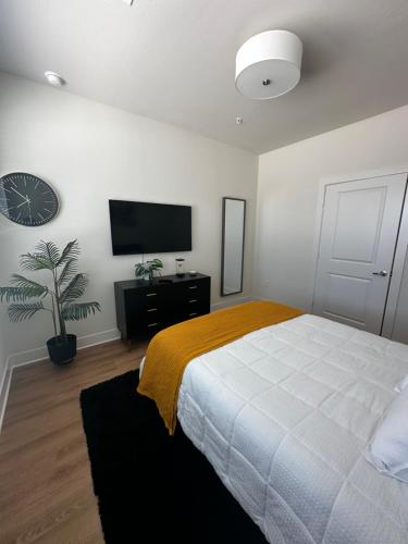 a bedroom with a bed and a flat screen tv at Devine living in the med center in Houston