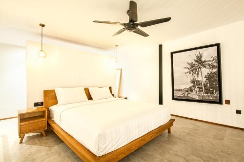1 dormitorio con 1 cama y ventilador de techo en Spacious Loft 200m From Canggu Beach en Canggu